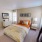 carpeted bedroom with large windows and private bathroom